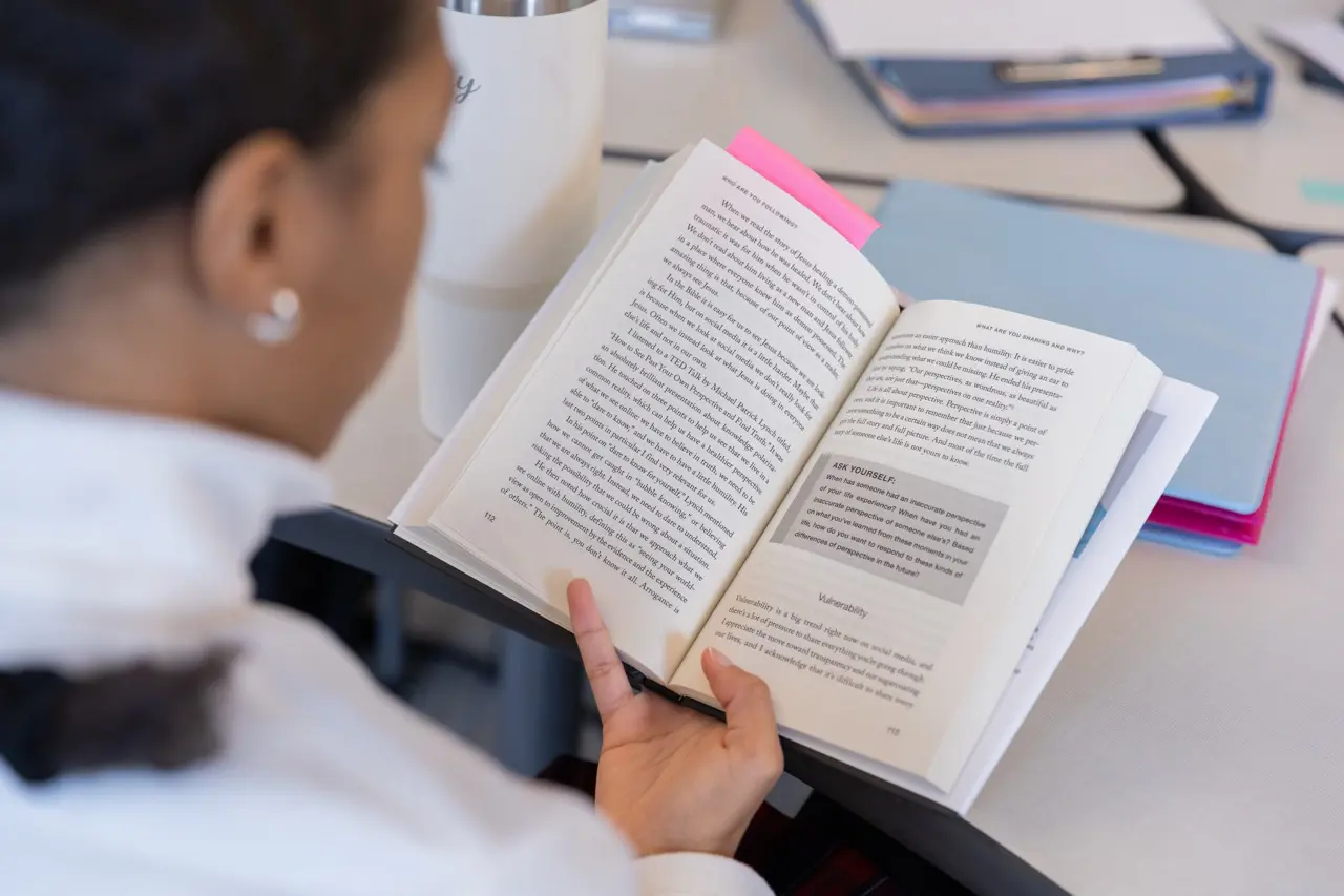 Upper School student reading a book on following Jesus