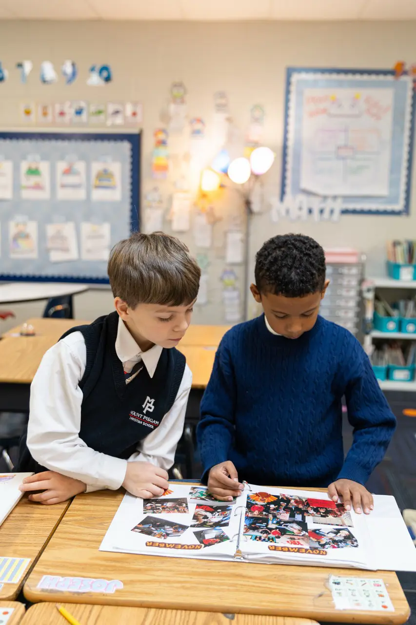 Two Lower School boys looking through a class photo album