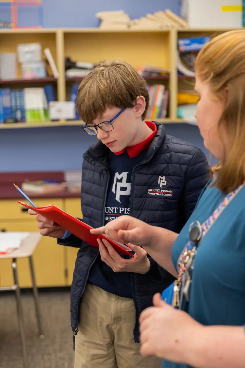 Teacher giving feedback to a Middle School student
