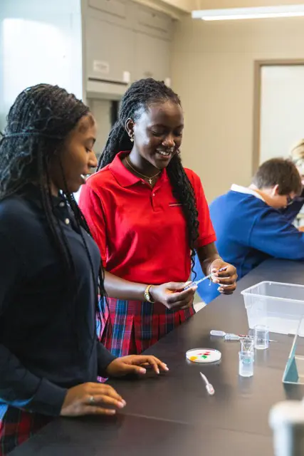 Upper School students smiling during a science lab