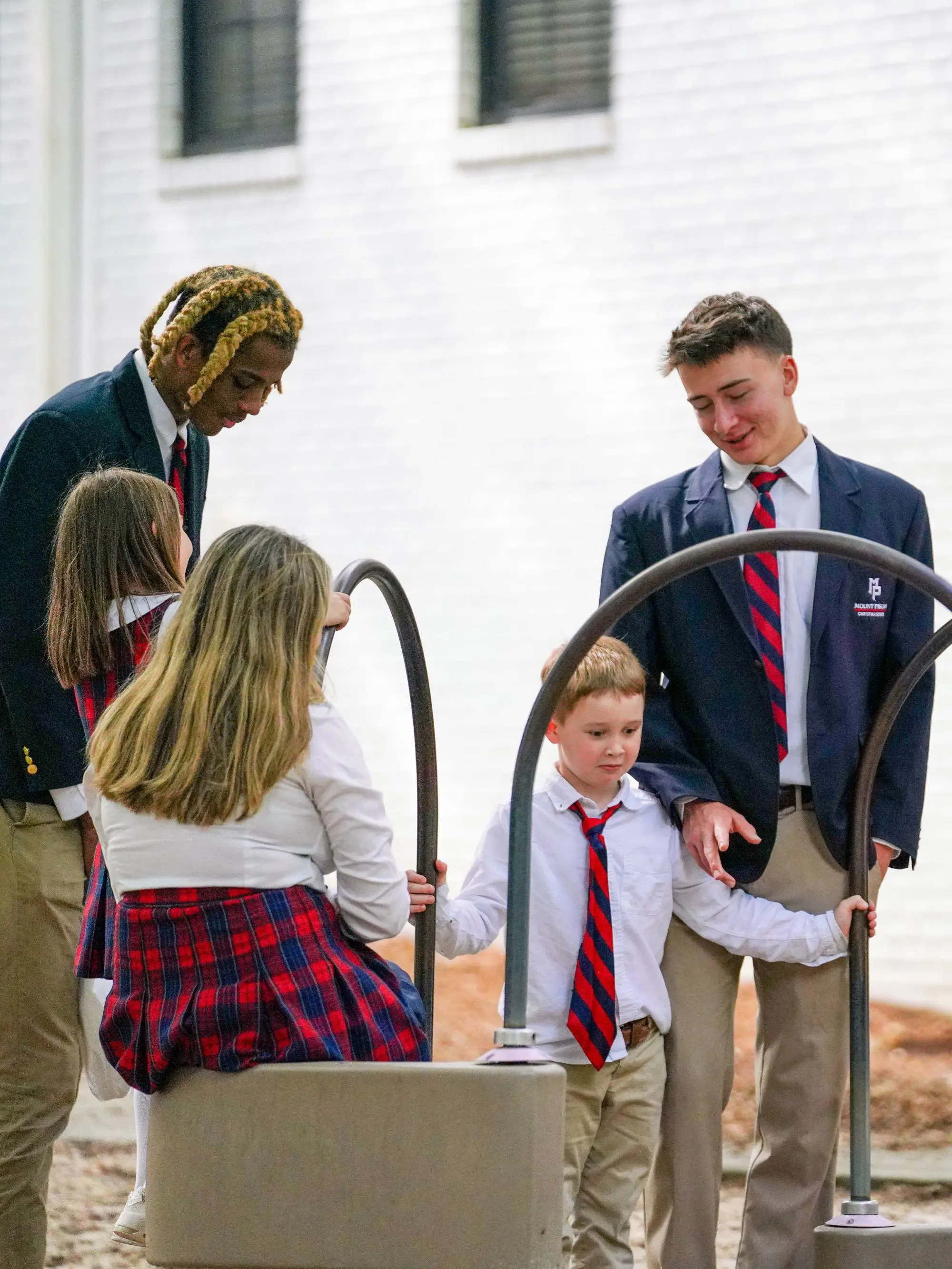 Upper school students supervising lower school students on playground