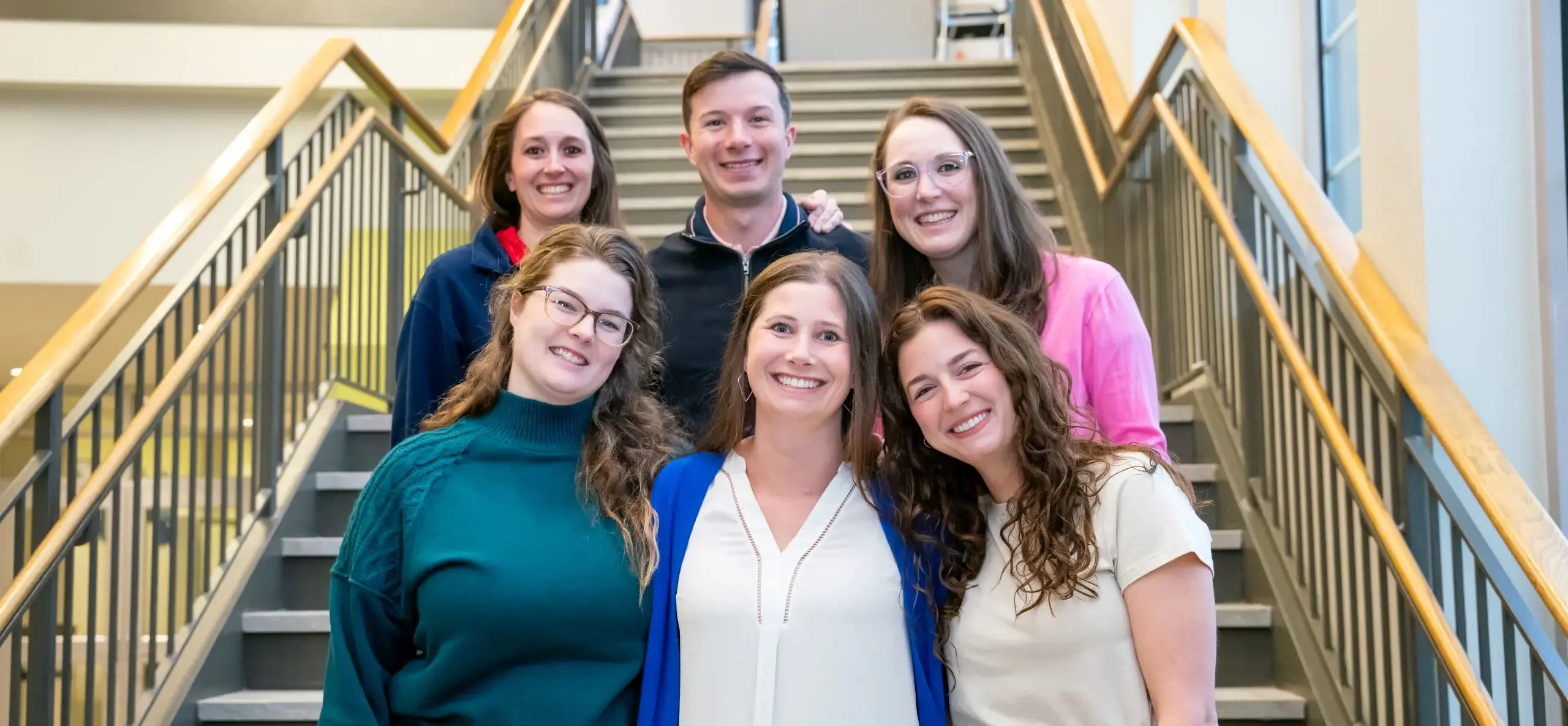 Faculty standing on stairs