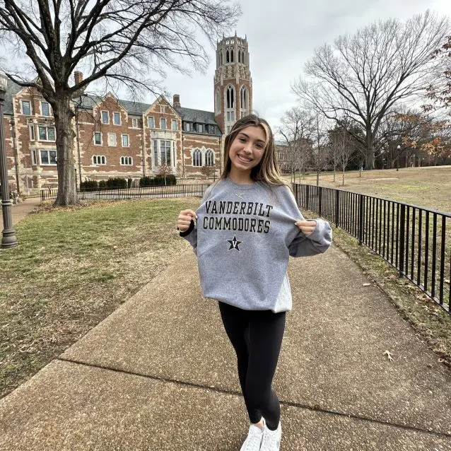 Andrea smiling outside college building