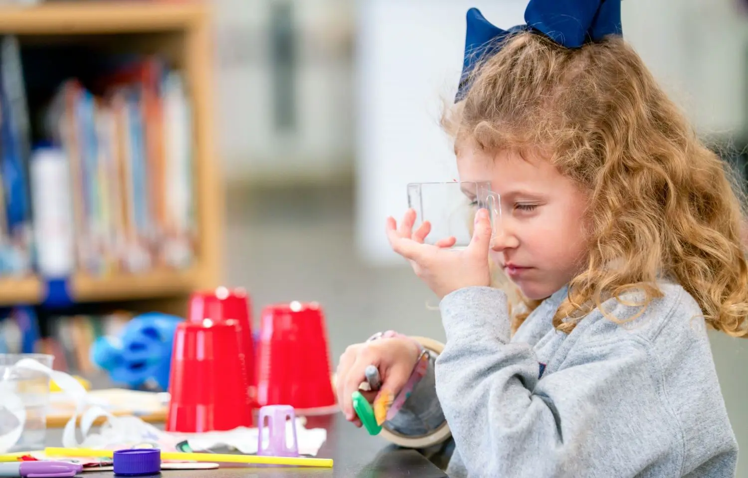 Student looking through a clear beaker