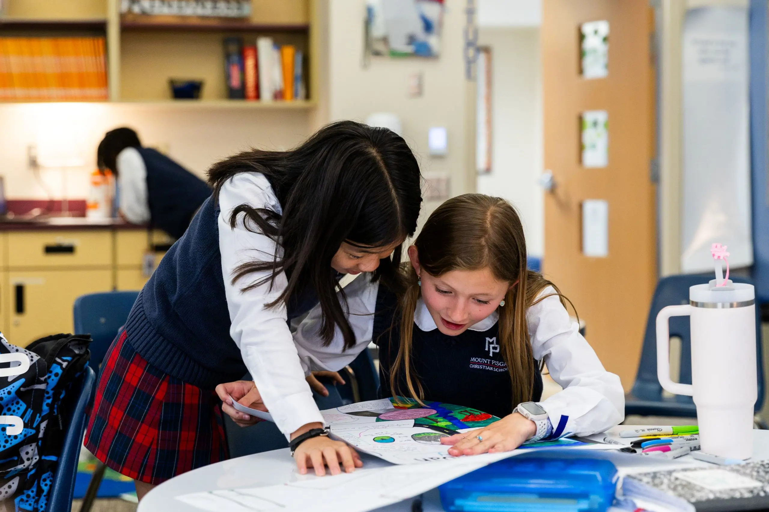 Two students looking at schoolwork on the table