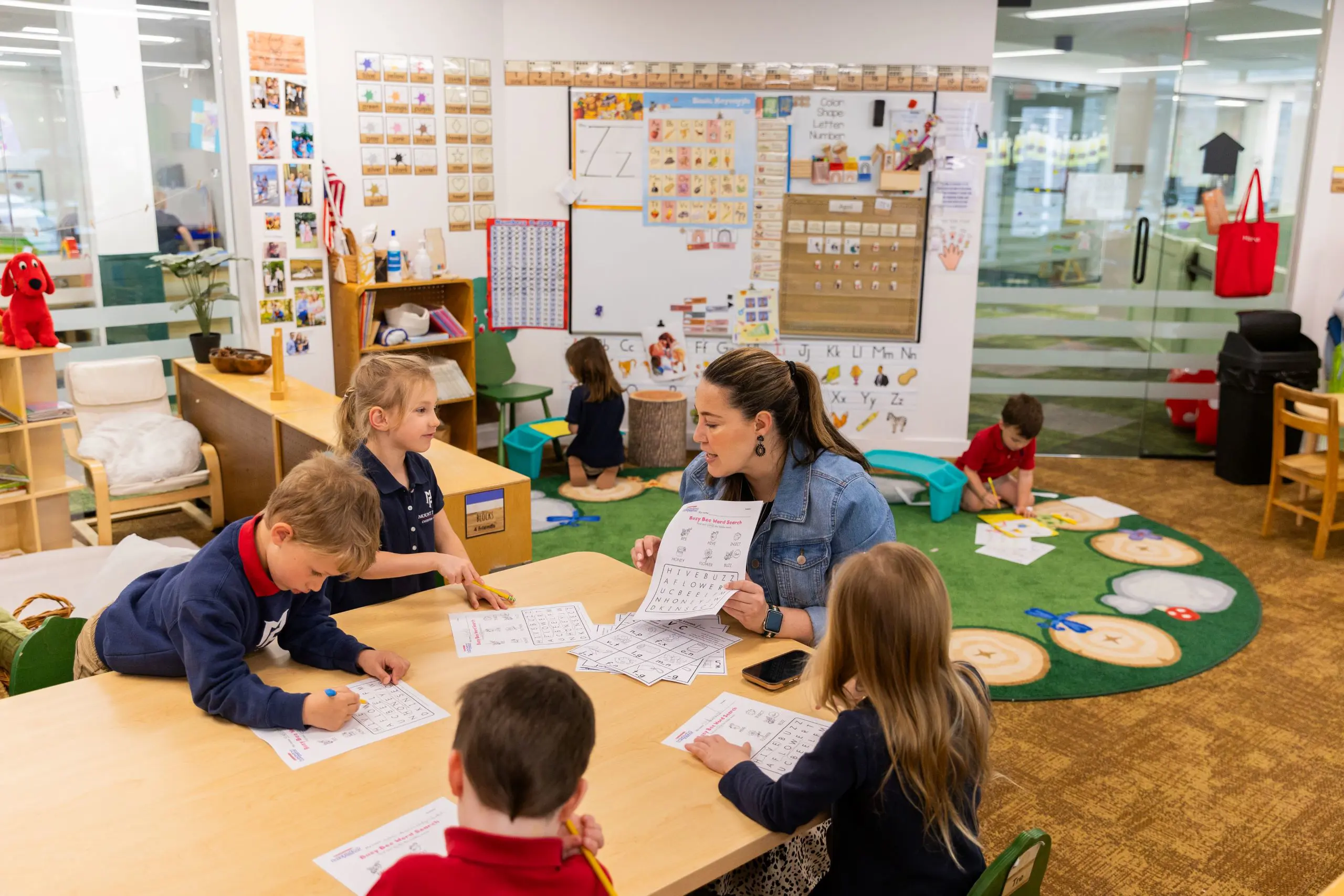 Teacher and students sitting around tables in classroom