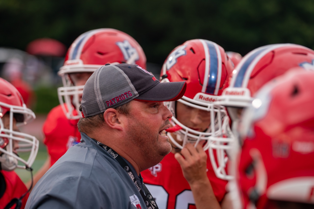 Coach instructing football team