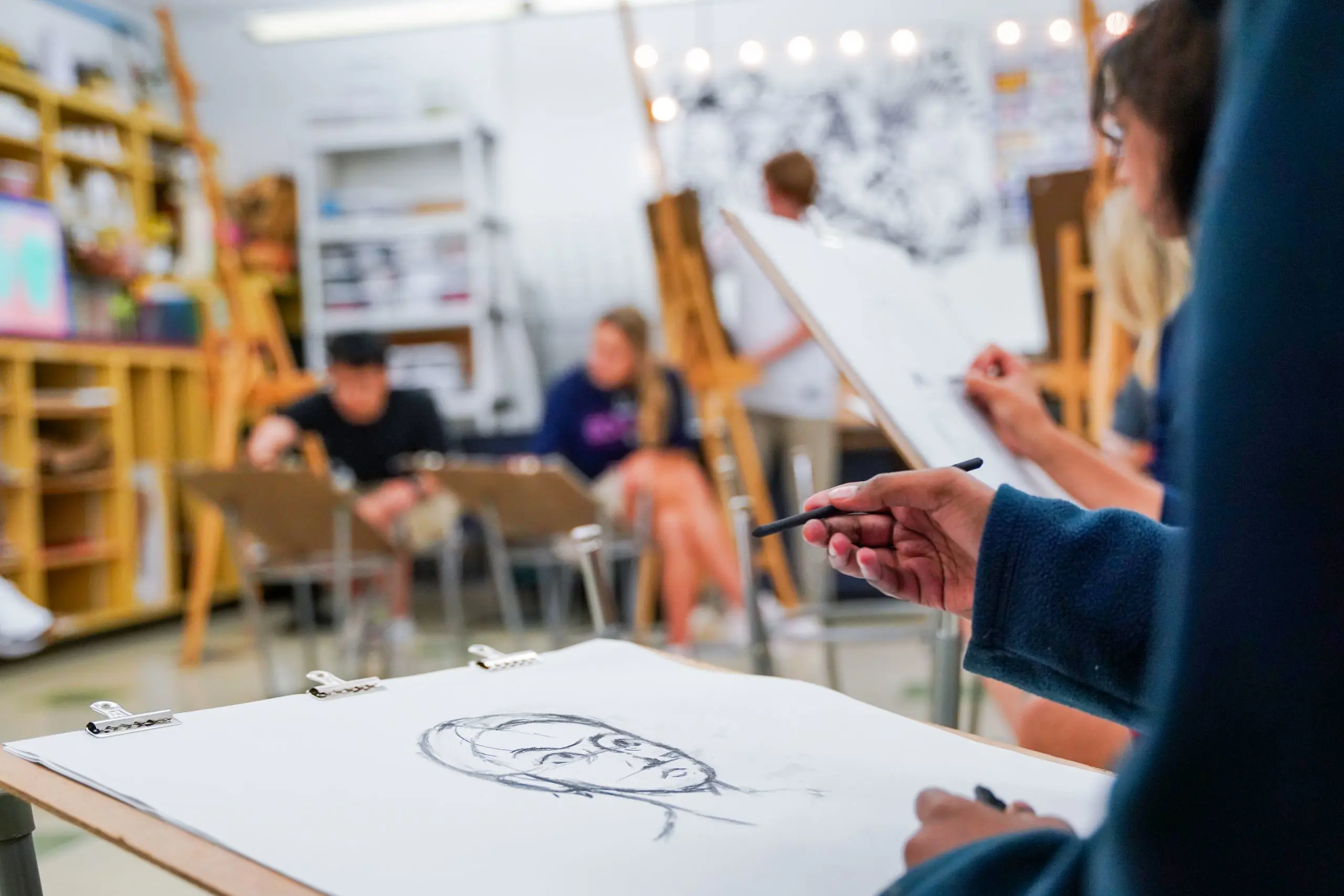 A hand sketching a head